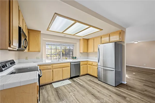 a kitchen with a refrigerator sink and cabinets