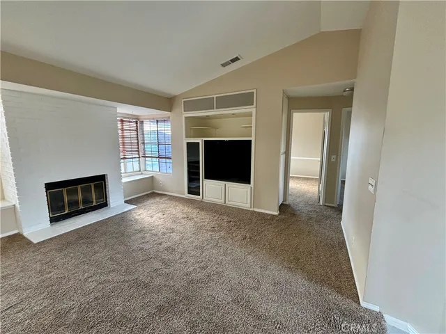 an empty room with fireplace and windows