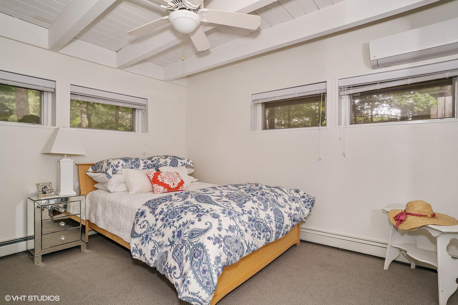 64 Fells Pond Road Mashpee, MA 02649 - Photo 18 of 25 a bedroom with a bed and a chandelier