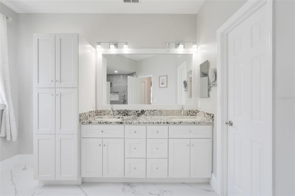 3862 Beacon Ridge Way Clermont, FL 34711 - Photo 19 of 56 a bathroom with a granite countertop sink a mirror and a vanity