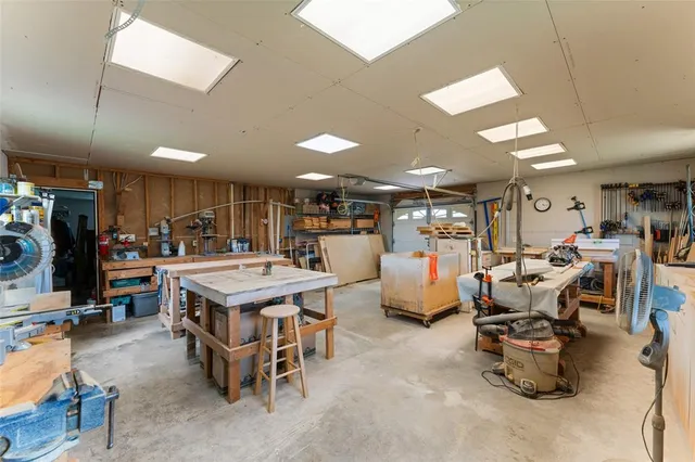 a open kitchen with stainless steel appliances a dining table and chairs in it