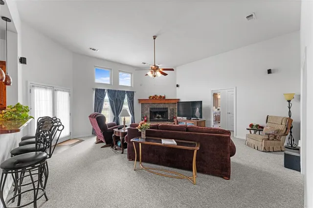a living room with furniture a fireplace and a chandelier