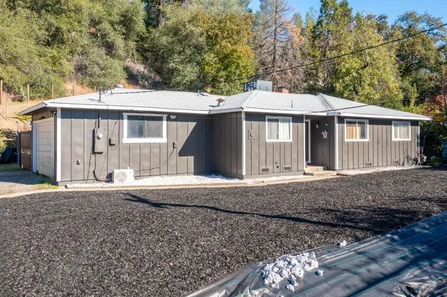 a front view of a house with a garden and yard