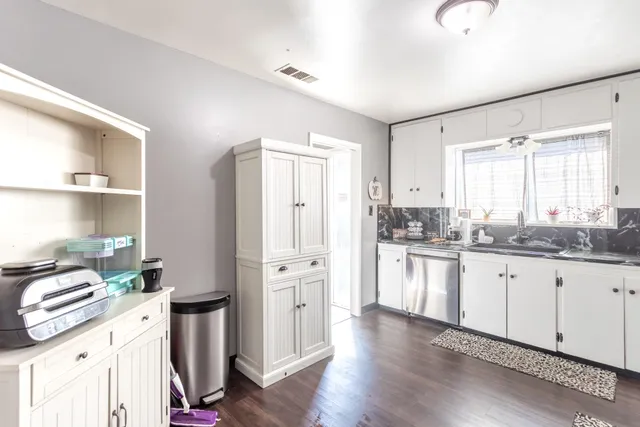 a kitchen with granite countertop white cabinets and white appliances