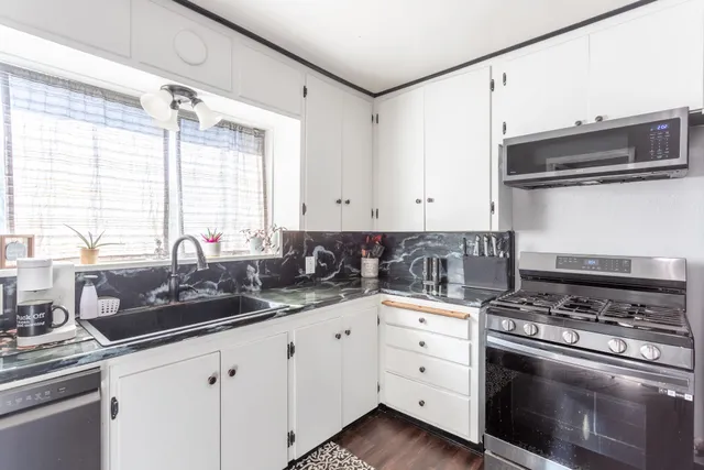 a kitchen with white cabinets and appliances