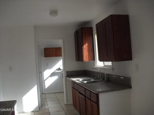 a kitchen with granite countertop a stove and a sink