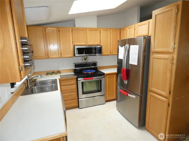 a kitchen with stainless steel appliances a refrigerator stove and microwave