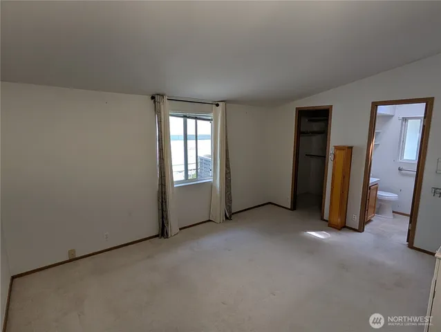 an empty room with closet and mirrors
