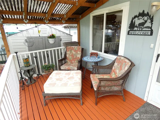 a balcony with wooden floor table and chairs