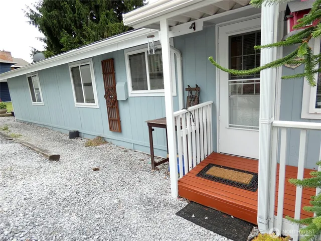 a backyard of a house with wooden fence and large windows