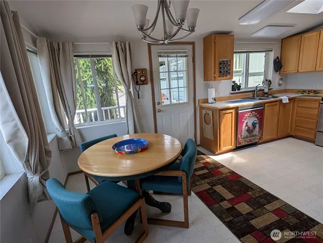 a kitchen with a table chairs a stove a window and dining table