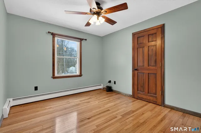 a view of an empty room with window and a ceiling fan