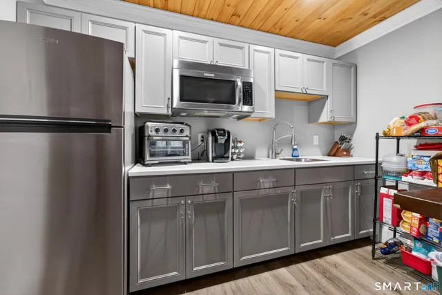 a kitchen with stainless steel appliances a refrigerator a sink a stove a microwave and wooden cabinets