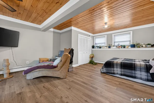 a bedroom with furniture and wooden floor