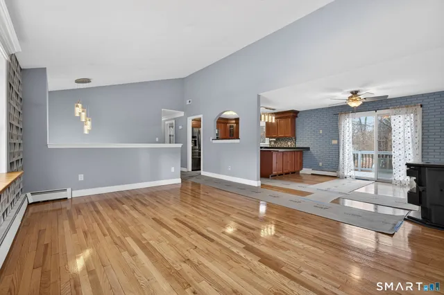 a view of empty room with wooden floor and windows