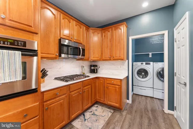 a kitchen with stainless steel appliances granite countertop a sink a stove and a refrigerator