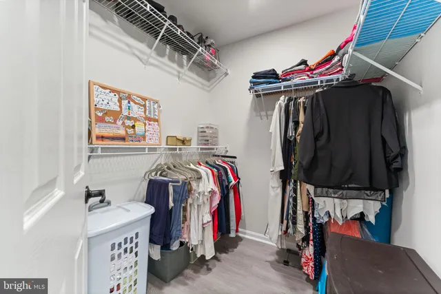 a view of walk in closet with clothes and shoes