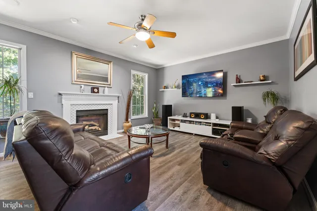 a living room with furniture a ceiling fan and a rug
