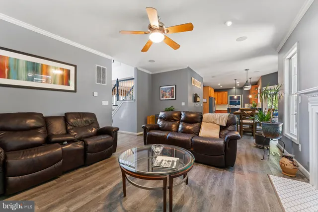 a dining room with furniture a chandelier and wooden floor