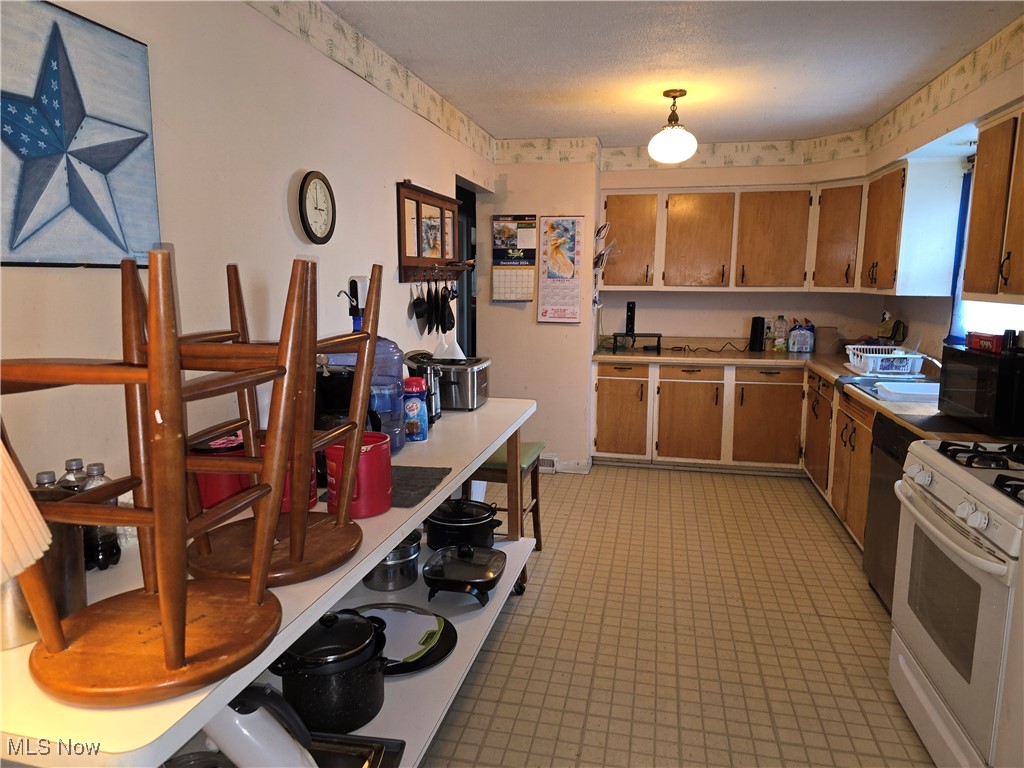 1516 Scenic Way Akron, OH 44310 - Photo 3 of 10 Kitchen with light countertops, white gas stove, and stainless steel dishwasher