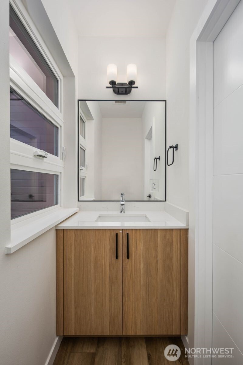 548 South Cloverdale Street, Unit D Seattle, WA 98108 - Photo 22 of 40 a bathroom with a sink and a mirror