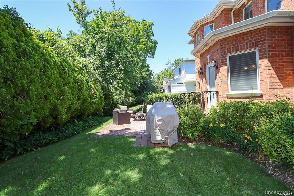 24 Steamboat Road Great Neck, NY 11024 - Photo 27 of 28 View of green lawn with a patio and an outdoor hangout area