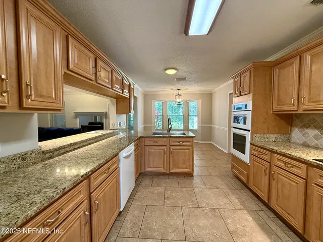 a large kitchen with stainless steel appliances granite countertop a large stove top oven a sink and dishwasher