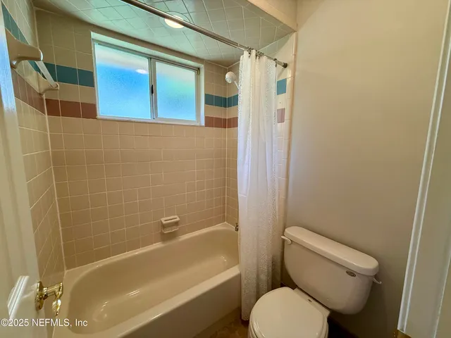 a bathroom with a toilet and a bathtub