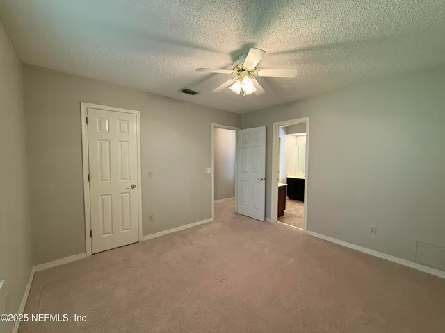 an empty room with closet and windows