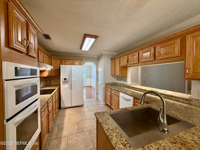 a kitchen with a refrigerator and more cabinets