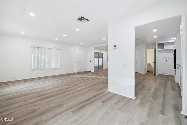a view of empty room with wooden floor