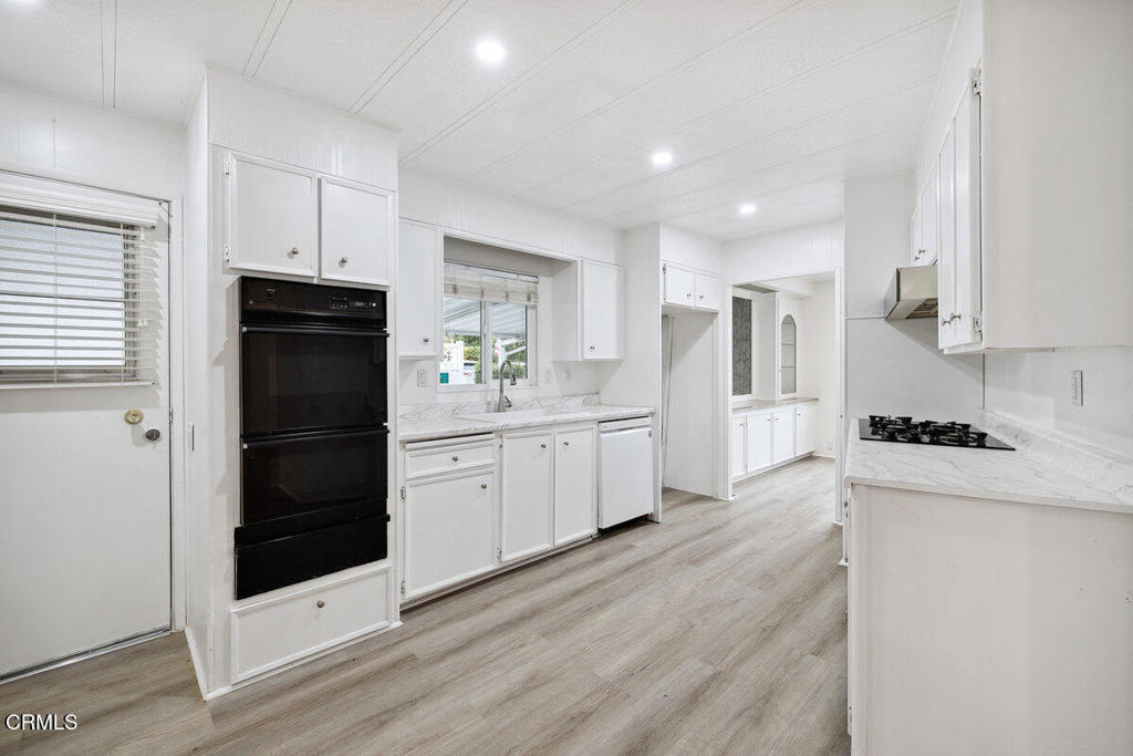 206 Browning Avenue, Unit 206 Ventura, CA 93003 - Photo 16 of 36 a kitchen with granite countertop white cabinets and stainless steel appliances