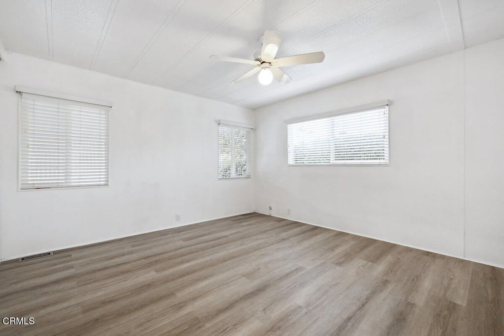 206 Browning Avenue, Unit 206 Ventura, CA 93003 - Photo 18 of 36 a view of an empty room with wooden floor and a window