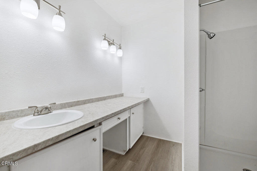 206 Browning Avenue, Unit 206 Ventura, CA 93003 - Photo 19 of 36 a bathroom with a granite countertop sink and a mirror
