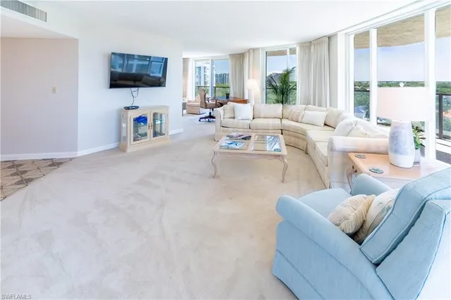 a living room with furniture and large windows