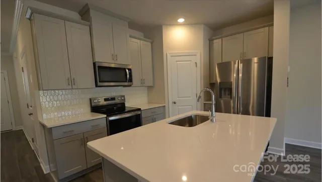 a kitchen with stainless steel appliances a refrigerator stove and microwave