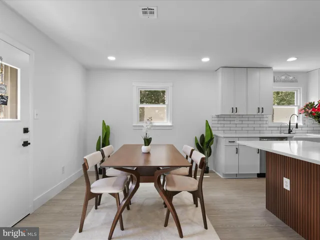 a kitchen with a table chairs sink and cabinets