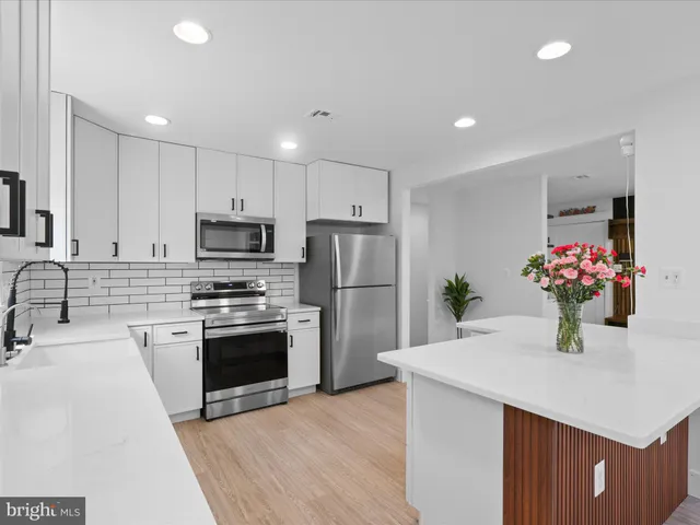 a kitchen with a sink stainless steel appliances and white cabinets