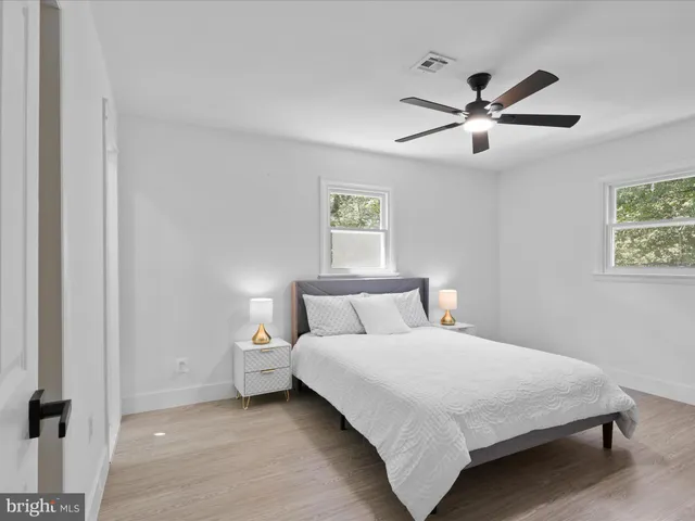 a bedroom with a large bed and a ceiling fan