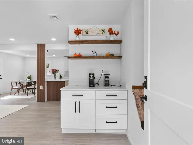 a kitchen with white cabinets and appliances