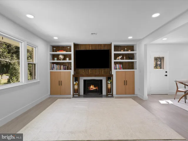 a living room with furniture a fireplace and a flat screen tv