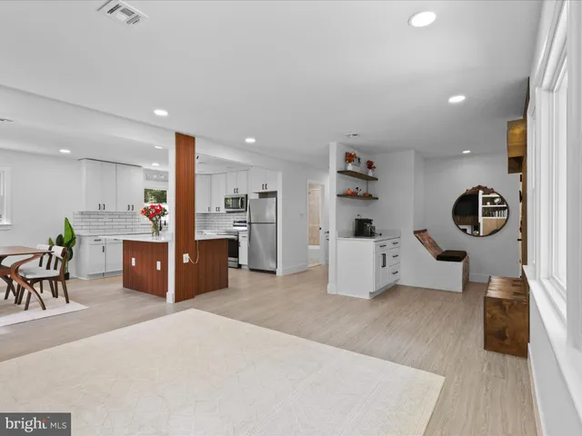 a living room with furniture and a refrigerator
