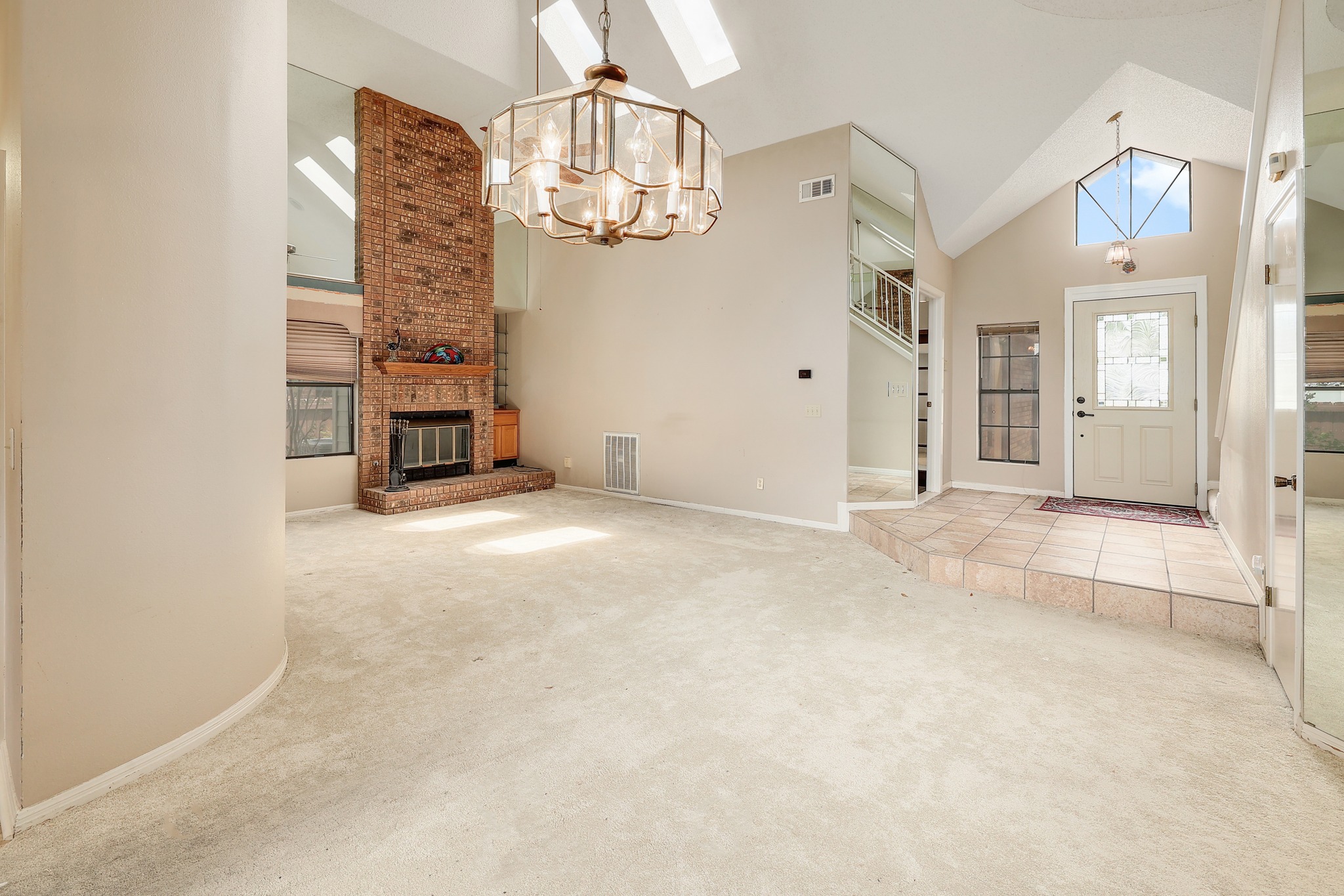 2202 Warfield Way Austin, TX 78728 - Photo 8 of 32 A spacious living room welcomes with a towering brick fireplace and an inviting tiled entryway.
