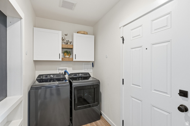 502 West 725 North Logan, UT 84321 - Photo 17 of 25 Laundry area featuring washer and clothes dryer, light wood finished floors, and cabinet space