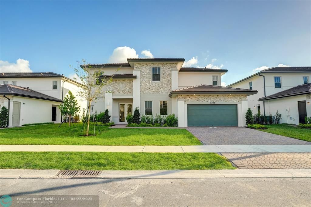 12328 Southwest 43rd Street Davie, FL 33330 - Photo 4 of 96 a front view of a house with a yard and garage