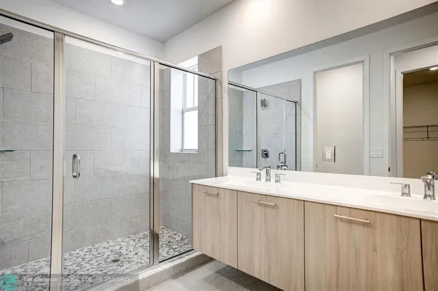 a kitchen with kitchen island stainless steel appliances a dining table chairs sink and cabinets