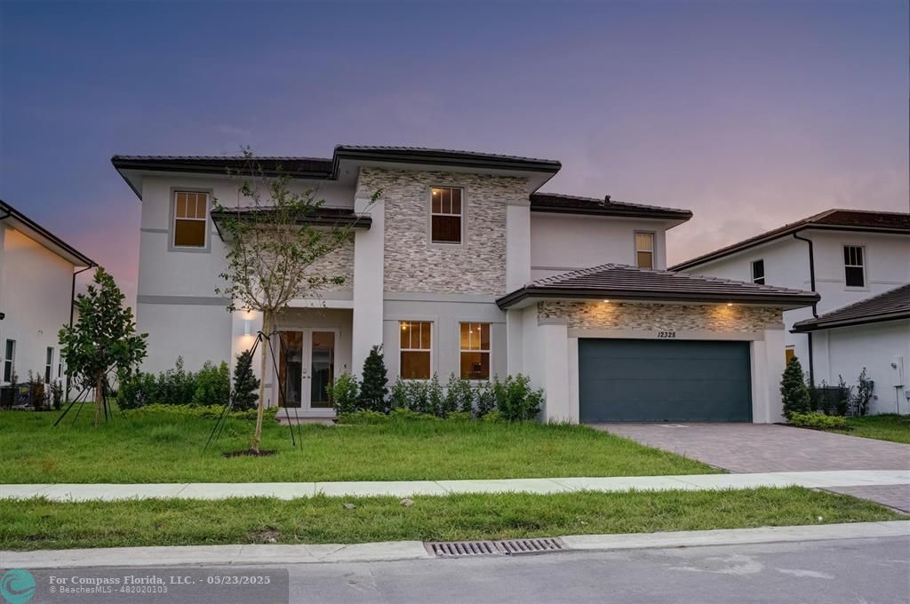 12328 Southwest 43rd Street Davie, FL 33330 - Photo 75 of 96 a front view of a house with a yard and garage