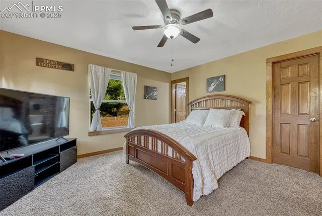 a bedroom with a bed flat screen tv and windows