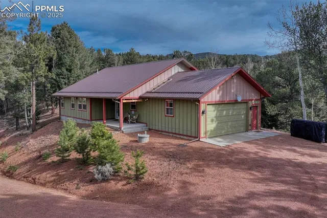 a view of a house with a yard and large tree