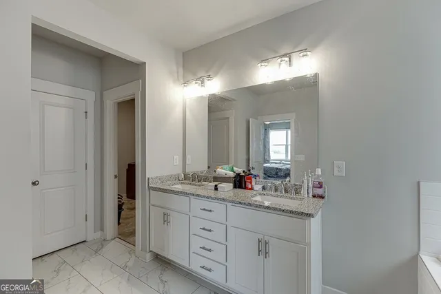 a bathroom with double sink and a mirror